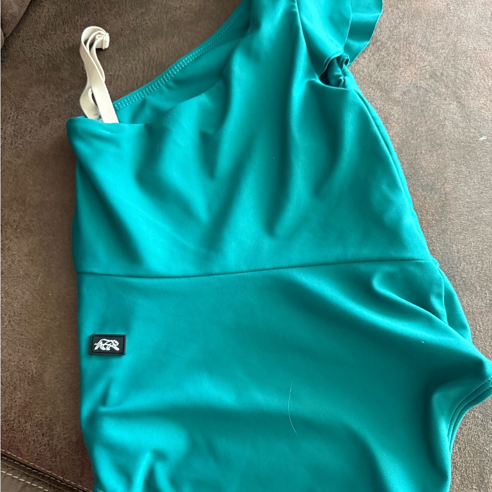 Scoop Neckline a strap was added so it helps stay up the strap is adjustable